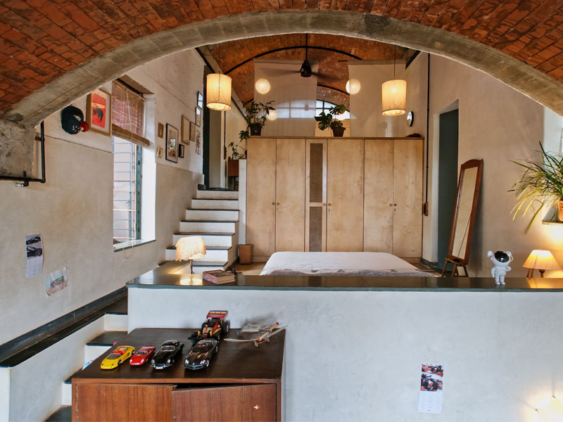 The couple’s bedroom is tucked beneath the living area in a vertically stacked unit, with no built-in furniture and simple privacy screens above – allowing the spaces to shift and adapt as needed – Beautiful Homes